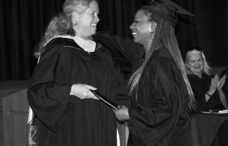 graduate smiling while receiving diploma