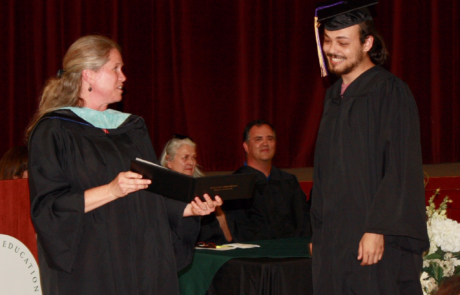 graduate walking up to receive diploma